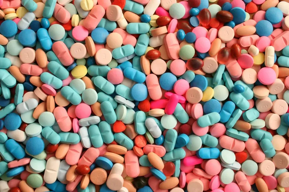 A dense assortment of colorful pills and capsules representing pharmaceutical and biotech work.