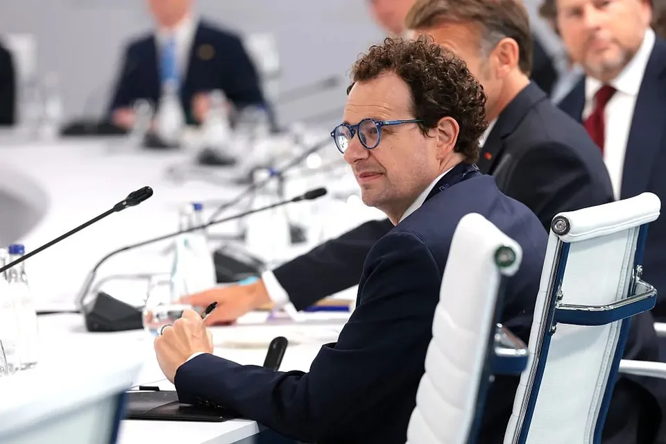 Anthropic CEO Dario Amodei seated at a conference table during a formal meeting.