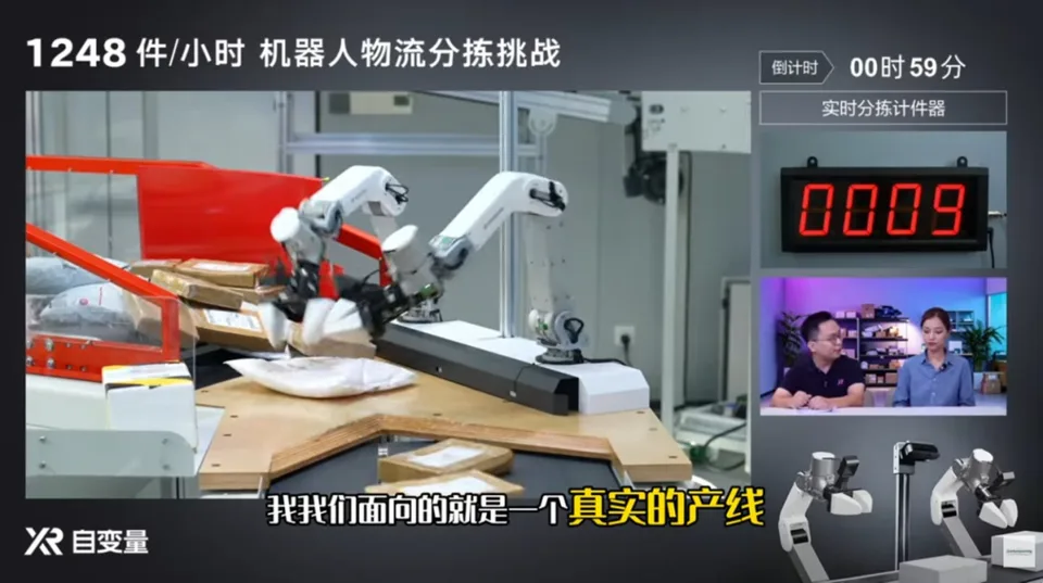 Two robotic arms sort items on a factory conveyor during a timed demonstration, with a performance display visible.