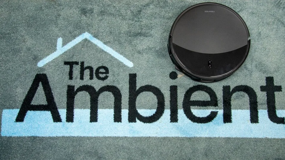 Roborock Saros 20 robot vacuum on a patterned carpet, shown from the front beside a smaller round robot.