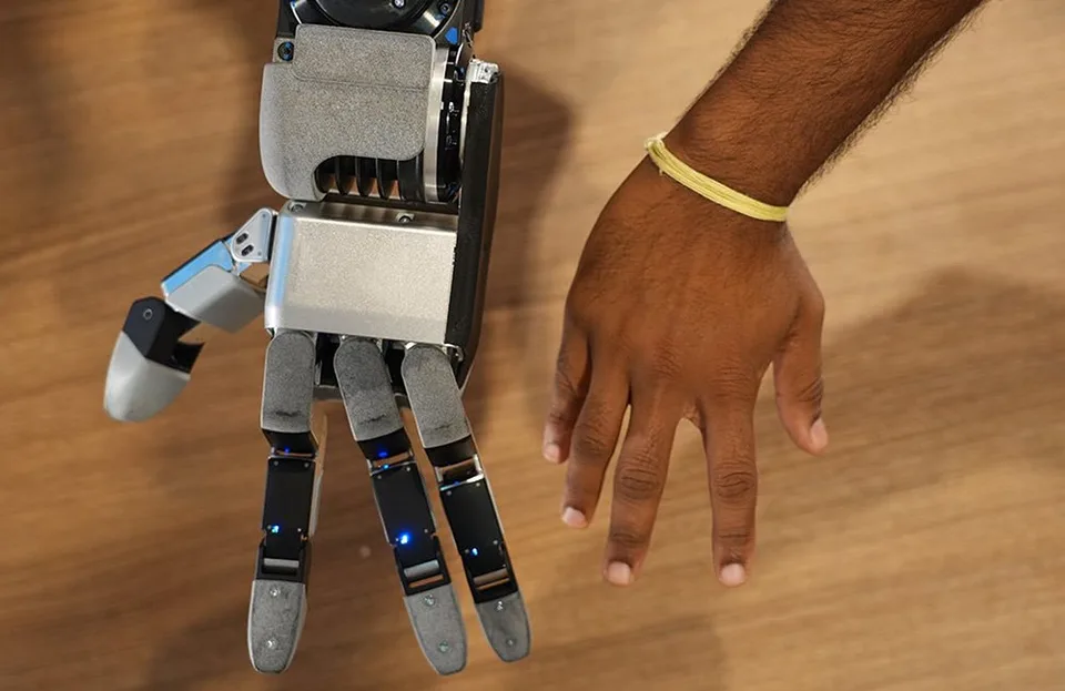 Boston Dynamics Atlas humanoid robot holding objects with its redesigned hand visible.