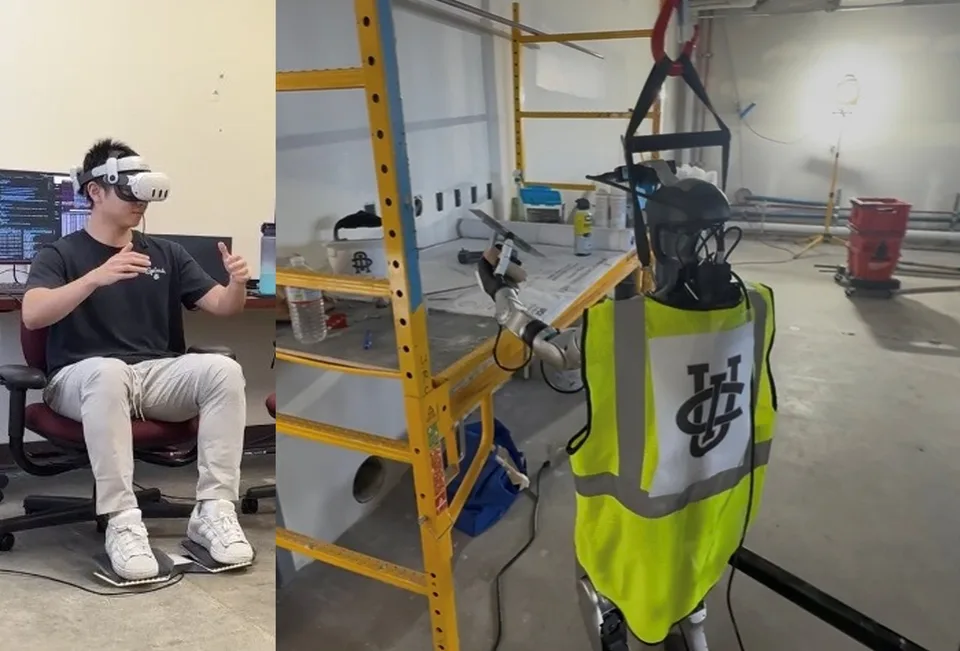 A seated operator wearing a headset and using foot pedals remotely guides a humanoid robot in a construction-like workspace; the robot wears a high-visibility vest.