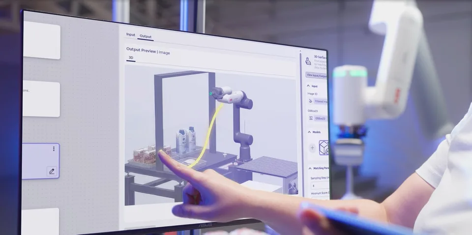 ABB robot and software interface shown in a robotics demonstration space, with a person interacting with a motion-planning display.